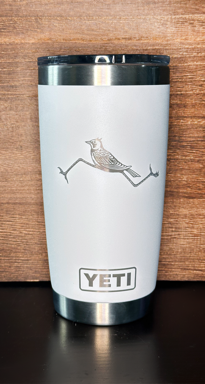 White YETI tumbler with a bird design on a wooden background